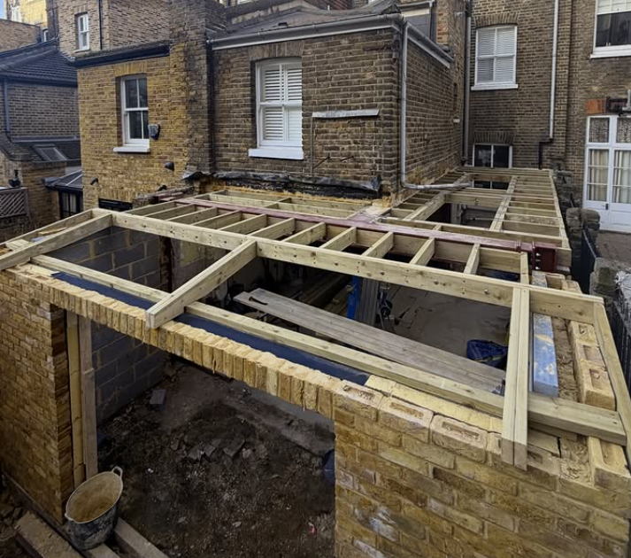 Timber frame addition under construction on a London brick property