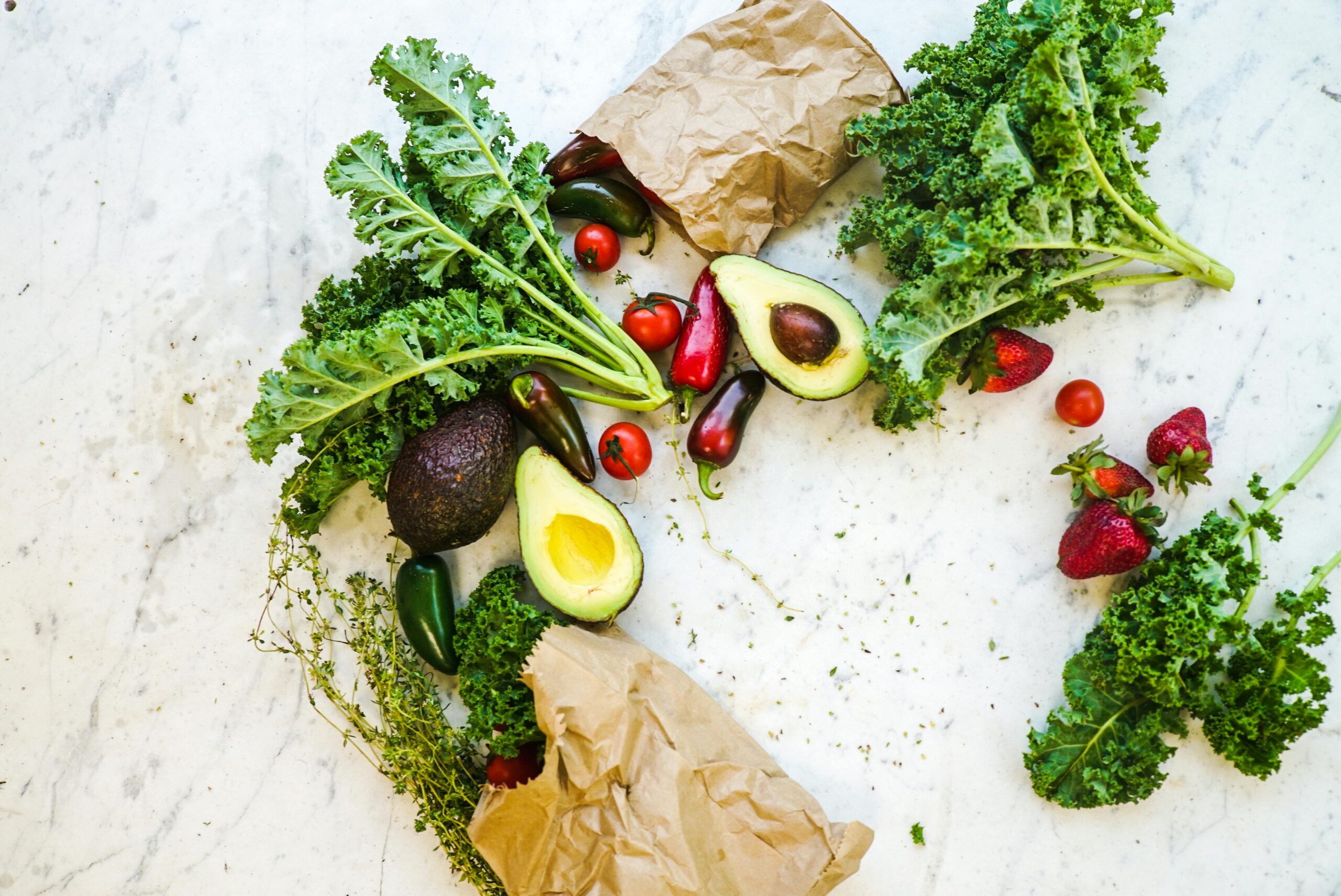 Fresh kale, avocados, and produce from grocery bags
